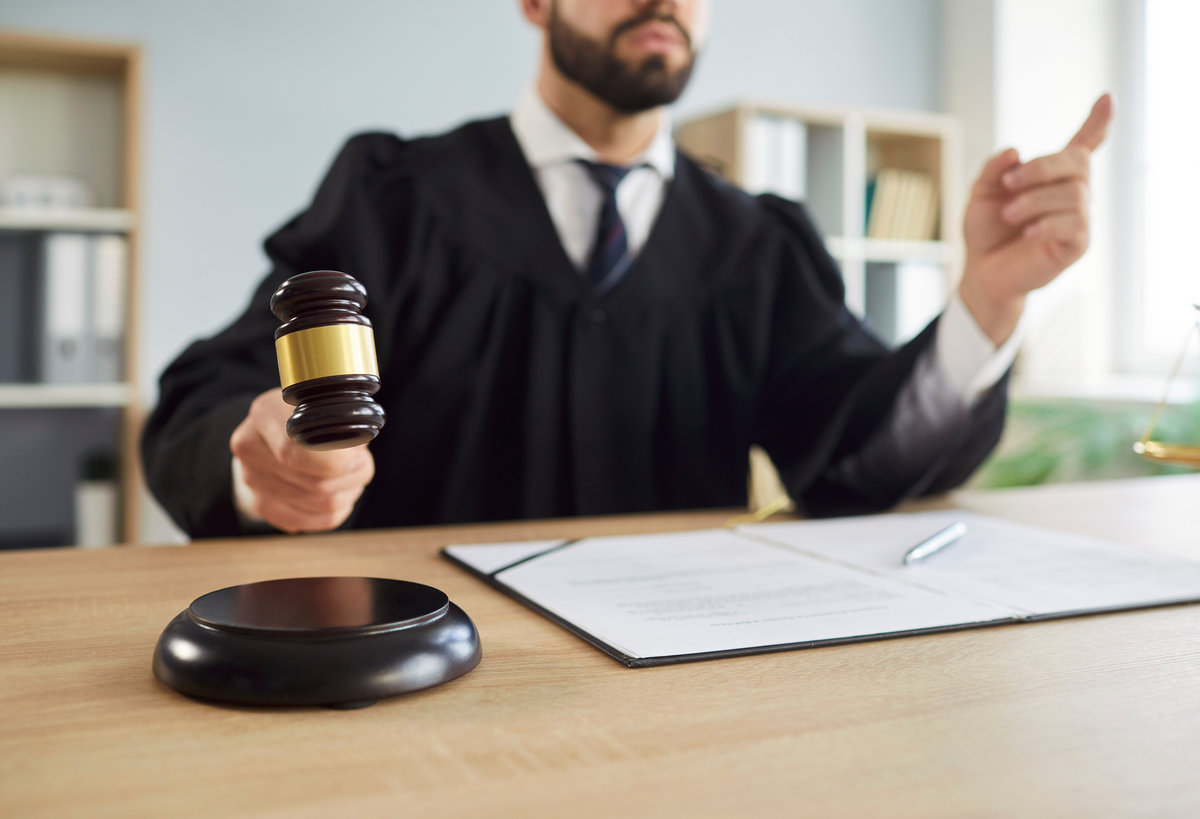 Judge banging a gavel on a wooden bench